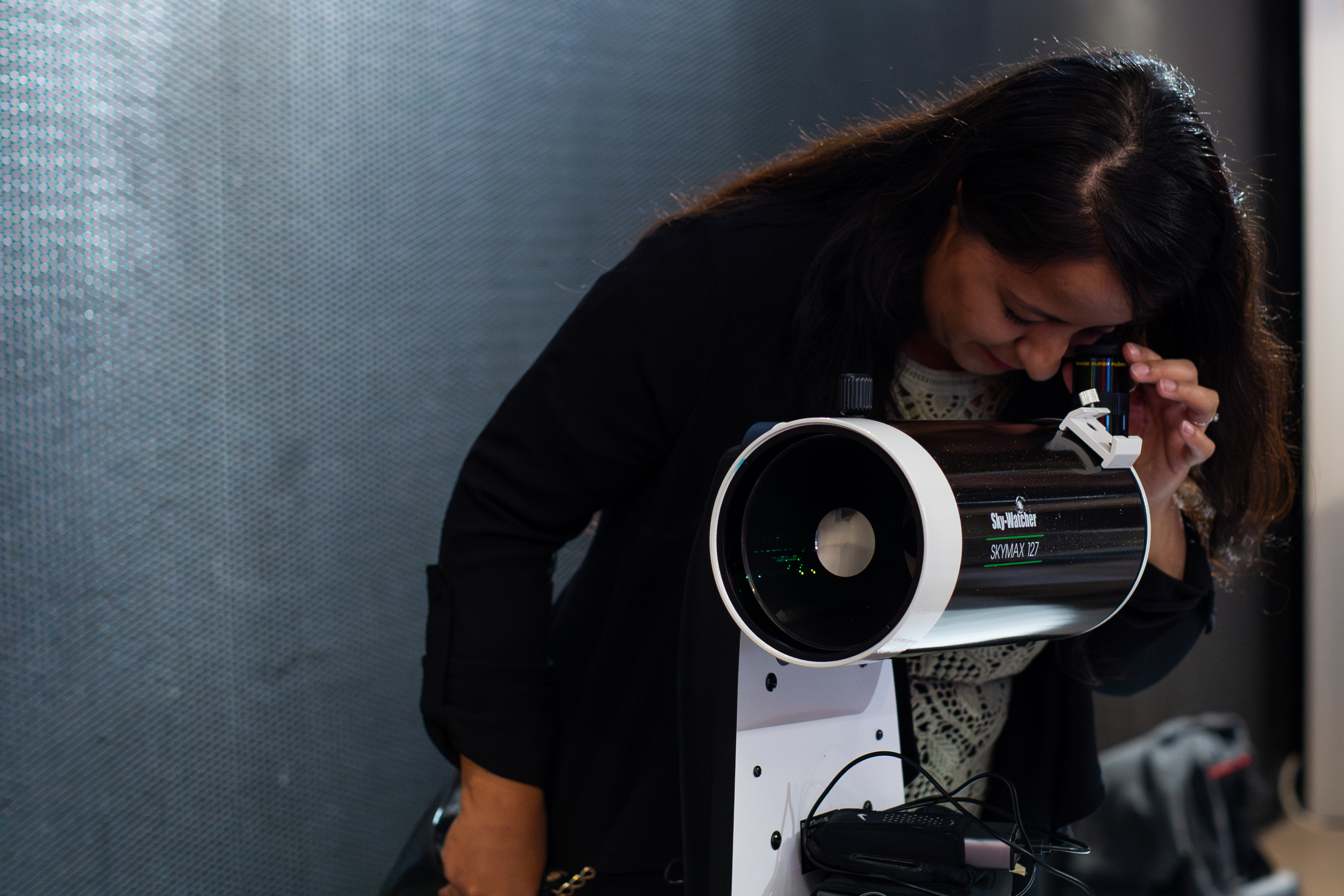 Woman looking through a telescope