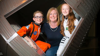 Mother and two children in spacesuits in the Mercury capsule in Into Space gallery