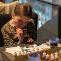 Child concentrating on painting a figure at To Boldly Game