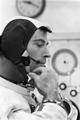 Apollo 10 astronaut John Young adjusting the strap of his communications cap aka Snoopy cap.