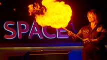 A member of the Discovery team with a large flame in the LIVE Space gallery