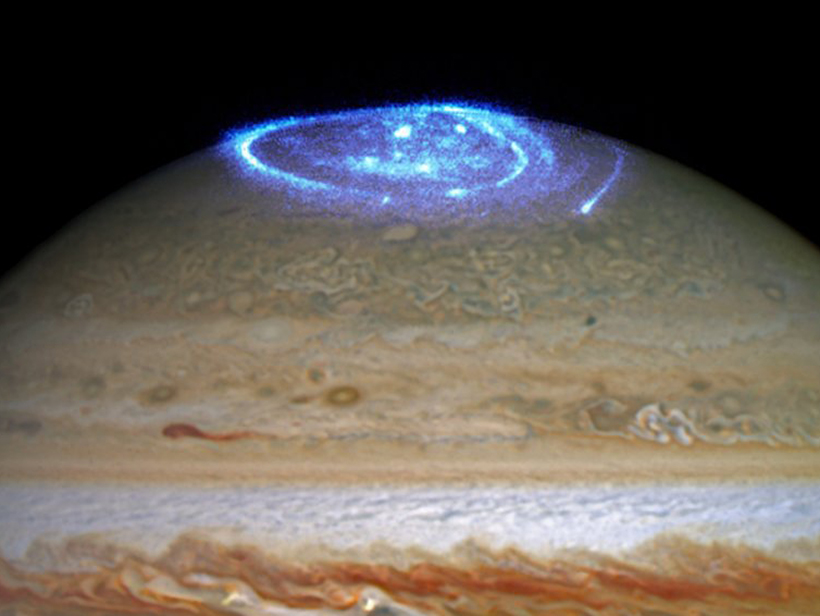 Auroras shine bright blue over Jupiter. 