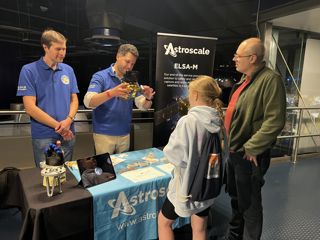 Astroscale team explaining to a family