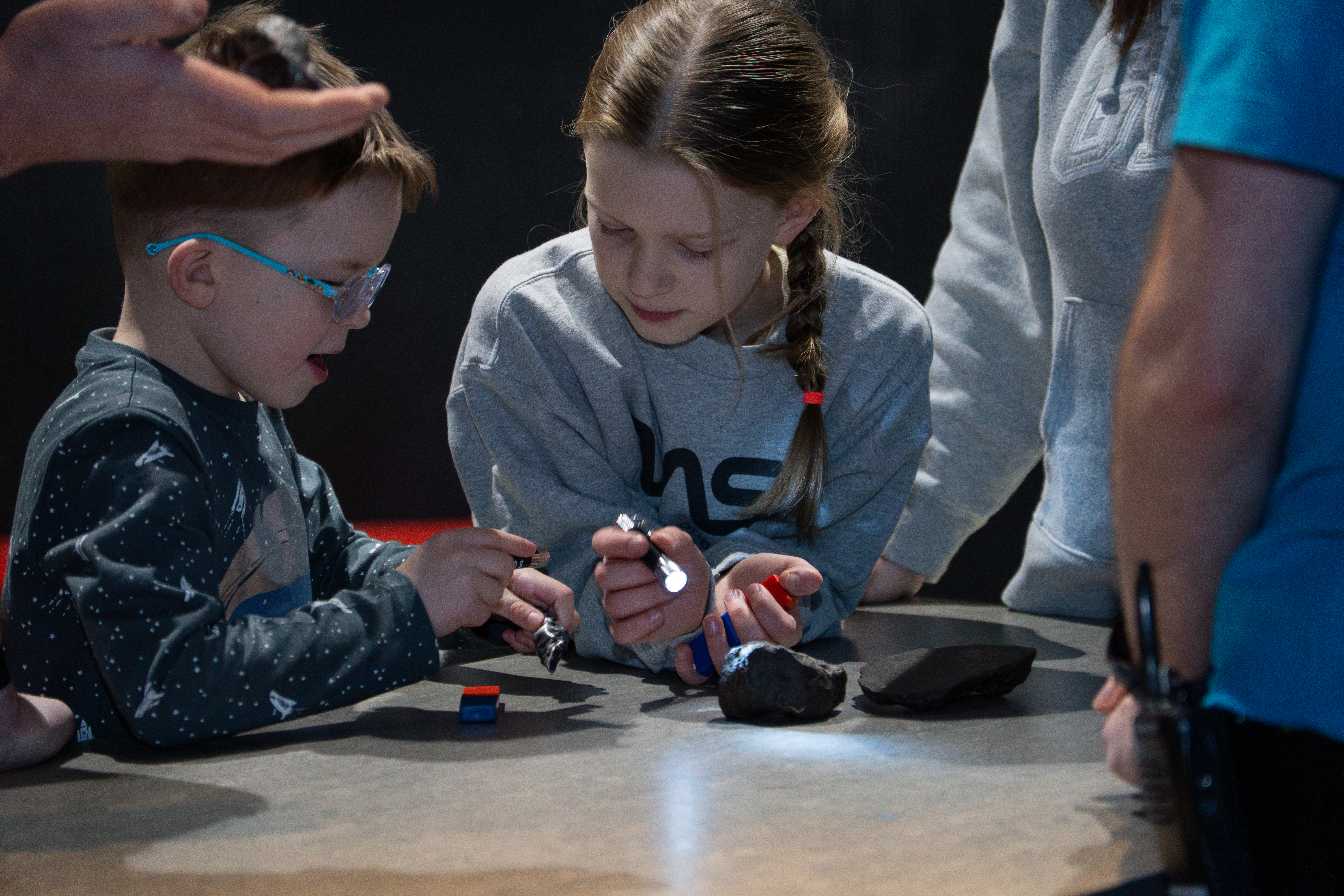 Two children with meteorites and magnets