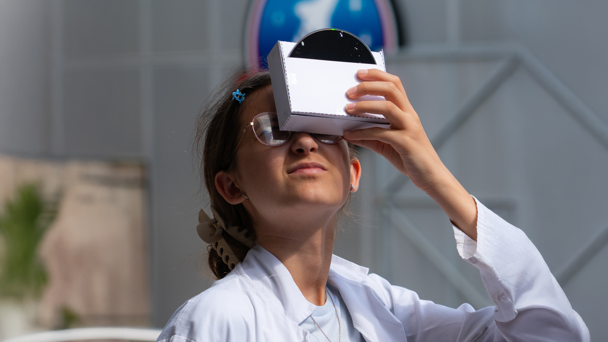 Young girl uses a pinhole constellation viewer in the main courtyard 16.9