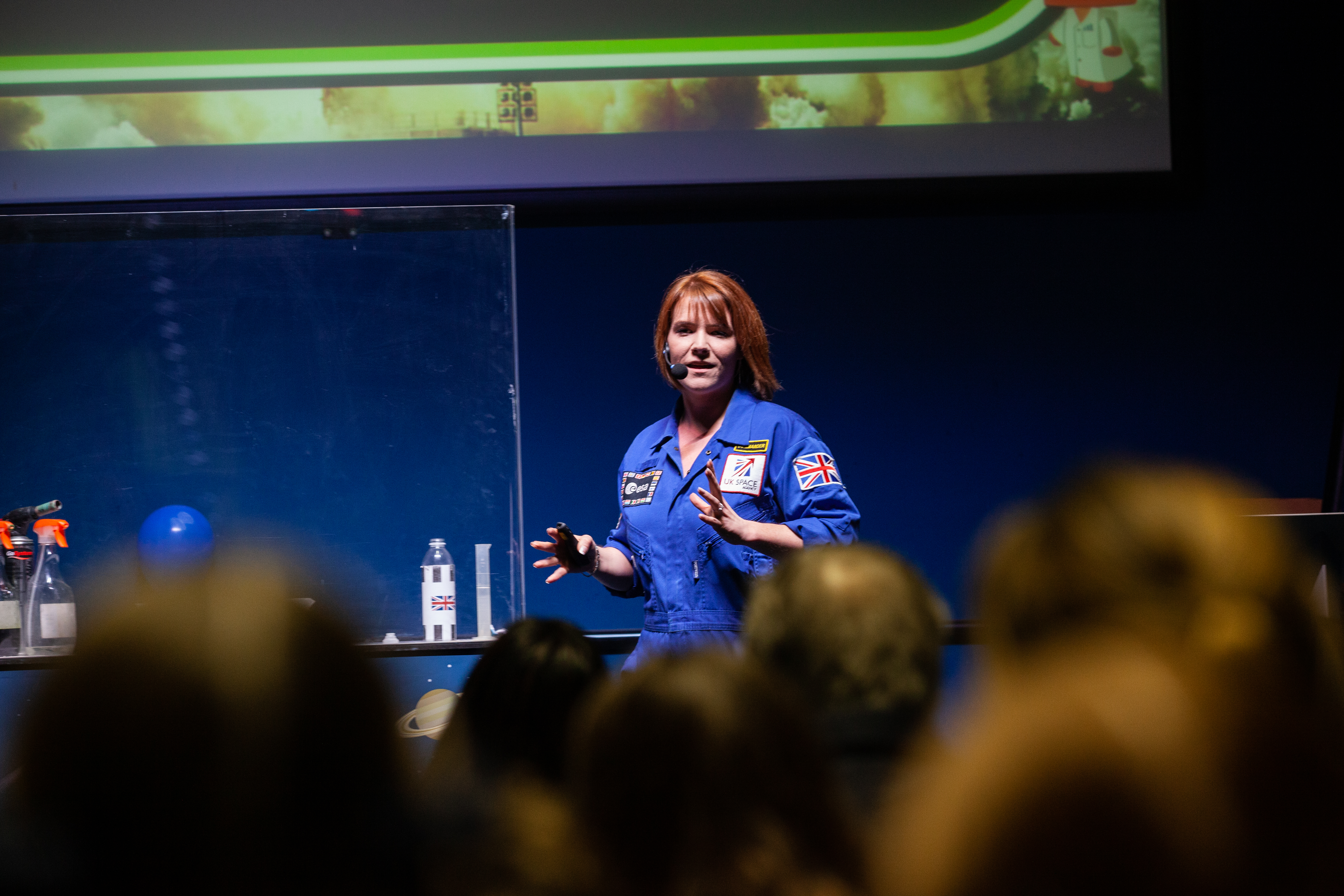 Education facilitator on LIVE Space stage presenting to a group of visitors