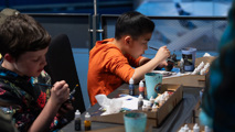 Two young boys painting figures at To Boldly Game