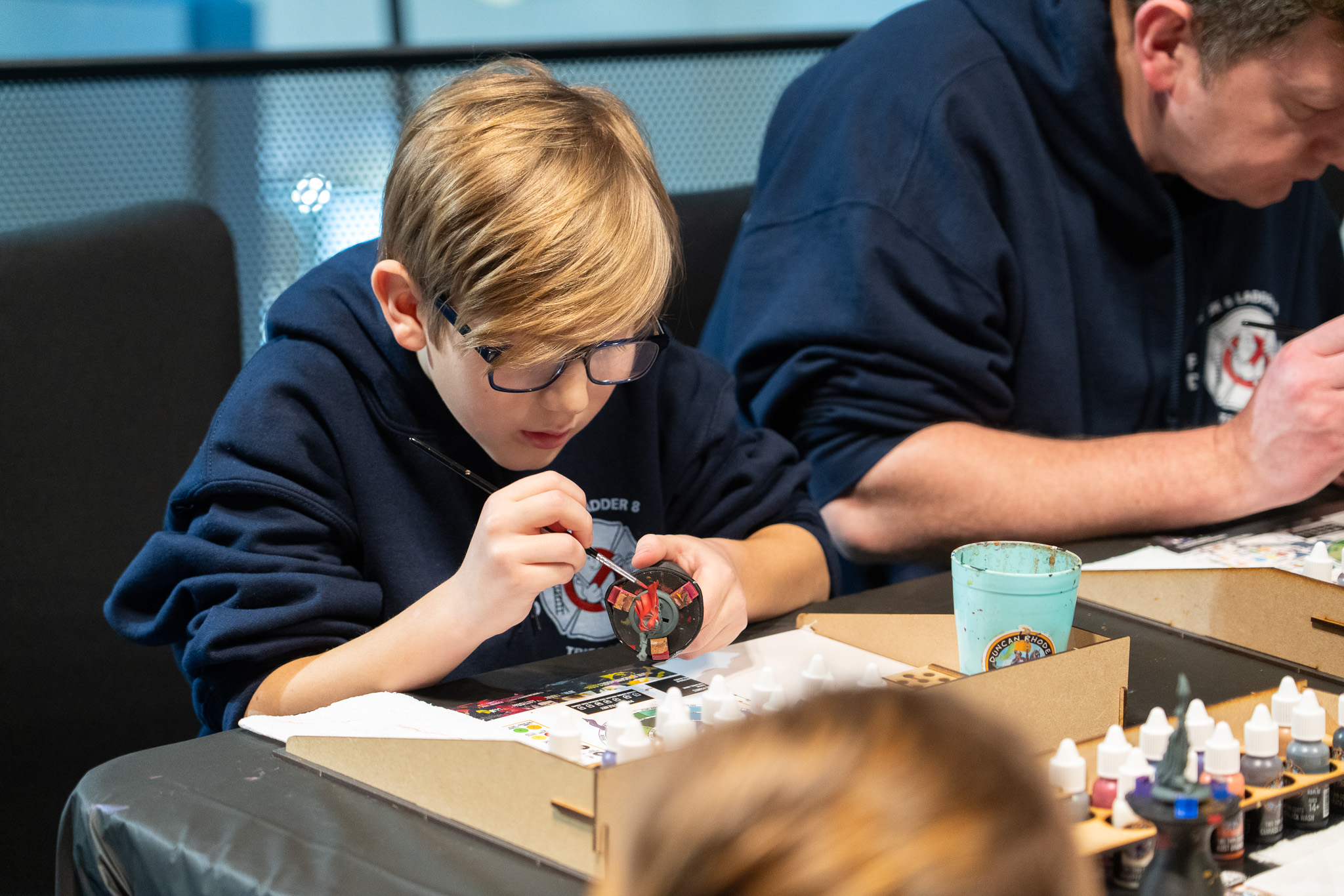 Child and adult painting figures at To Boldly Game