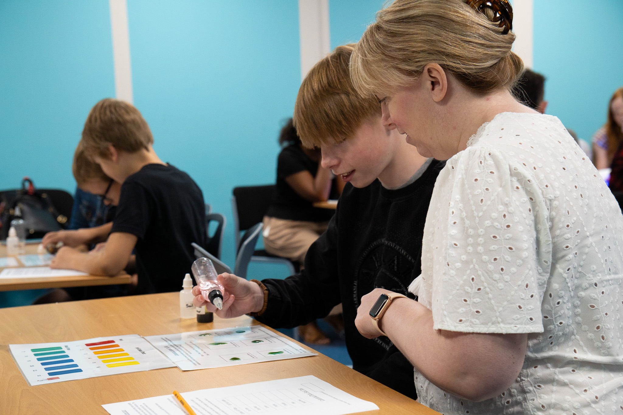 Older child and Mother participating in a science experiment during Home Education Day