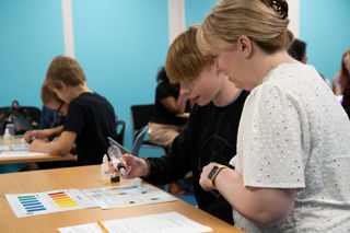 Older child and Mother participating in a science experiment during Home Education Day