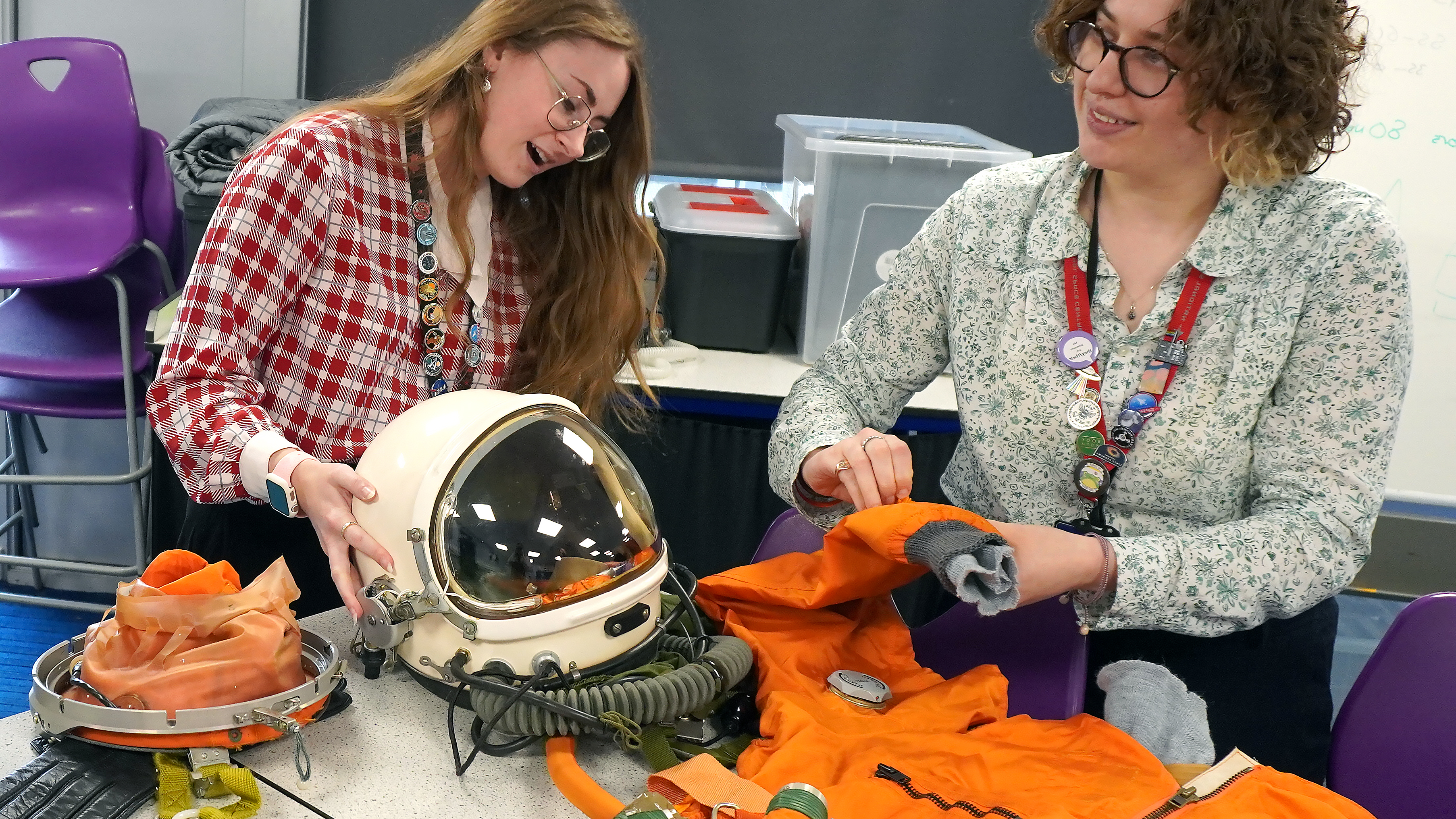 Two members of the Discovery team with a high altitude spacesuit at Space Club