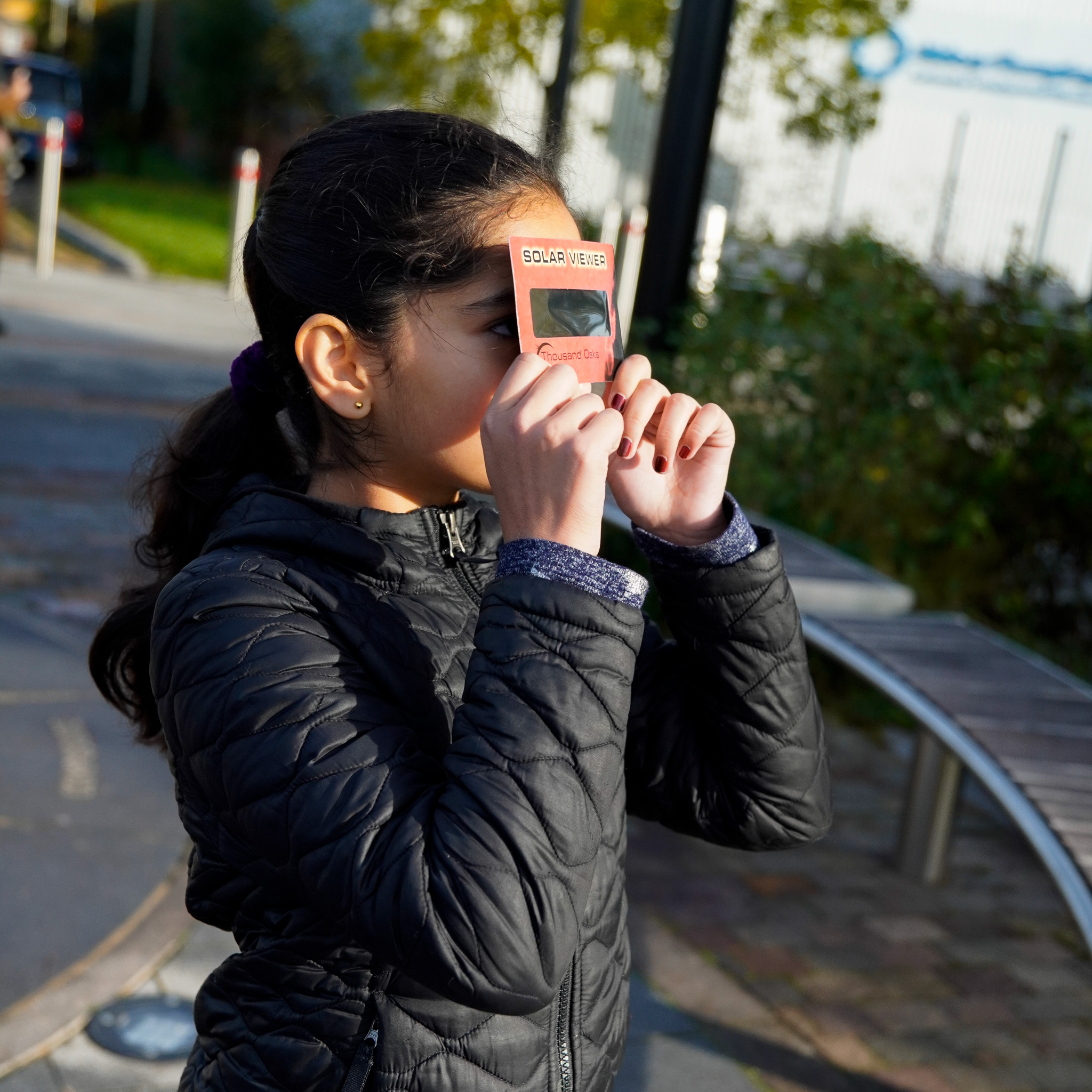 Young girl using an Eclipse Viewer to watch the solar eclipse safely