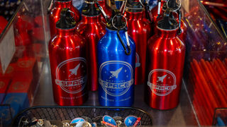 Red and Blue National Space Centre branded water bottles on display in the gift shop