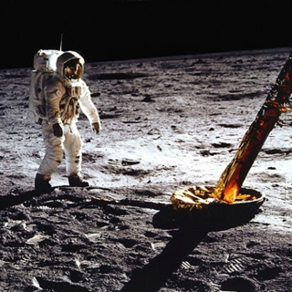 Buzz Aldrin walks on the surface of the Moon near a leg of the Lunar Module.
