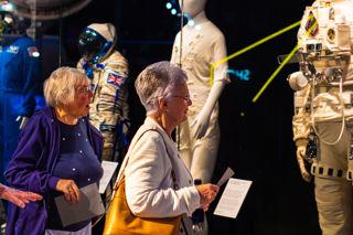 Two older ladies looking at the spacesuits in the Welcome Hall