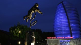 Rocket Tower and astronaut statue at night