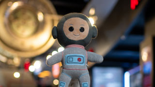 Ziggy toy in front of the Soyuz Capsule in the Welcome Hall