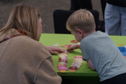 Mother helps young boy play an ice cream game at To Boldly Game