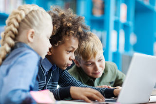 Three children learning online with a laptop computer